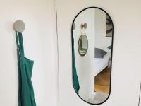 a mirror on a wall next to a bed at Ty Chou - Appartement Cosy - Centre Ville in Rennes