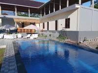 a swimming pool in front of a house at Scuba Tribe Bali dive-resort in Tulamben