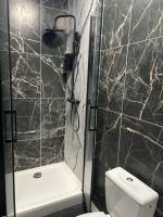 a bathroom with a toilet and a shower with marble walls at Hôtel de La gare-Les Floralies in Poitiers