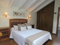 Un dormitorio con una cama blanca con cabecero de madera. en Pensión Arbidel, en Ribadesella