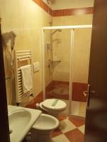 a bathroom with a shower and a toilet and a sink at Hotel Henry in Venice