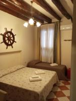 a hotel room with two beds and a steering wheel on the wall at Hotel Henry in Venice