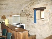 a kitchen with a stove and a counter with chairs at Maison d&#39;une chambre avec jardin clos a Tour de Faure in Tour-de-Faure