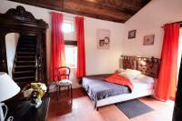 a bedroom with a bed with red drapes at Maison d&#39;une chambre avec jardin clos a Tour de Faure in Tour-de-Faure