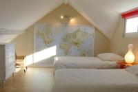 a attic bedroom with two beds and a map on the wall at La Maison du Fort de Fontain 
