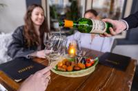 una persona vertiendo vino en una copa sobre una mesa en Hotel 1711, en Valkenburg