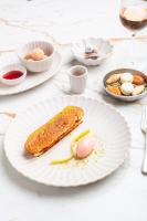 a white plate with a piece of food on a table at La Bastide Bourrelly - Mathias Dandine in Cabriès