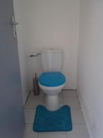 a bathroom with a toilet with a blue seat at Fruit à pain in Saint-François