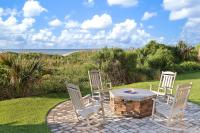 eine Terrasse mit drei Stühlen und einem Tisch mit Kamin in der Unterkunft Club Wyndham Westwinds in Myrtle Beach