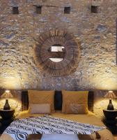Un dormitorio con una pared de piedra y un gran espejo. en La Casa Nomade, en Issigeac