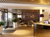 un vestíbulo de oficina con escritorio y sillas en Hôtel de l&#39;Orme, Akena, en Évreux