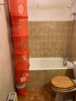 a bathroom with a toilet and a bath tub with orange shelves at 155 Piste dans mon canapé in Châtel