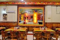 ein Restaurant mit Tischen und Stühlen und einem Gemälde an der Wand in der Unterkunft Hotel President in Gorakhpur