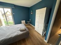 a bedroom with blue walls and a bed and a window at Comme à Garros - 218 in Mont-Saint-Aignan