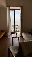 a living room with a table and a large window at Beautiful and Cozy Seaview Residence in Pozzuoli