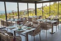 トラブゾンにあるFirst Joy Hotelのテーブルと椅子と窓のあるレストラン