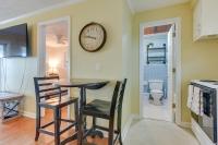 eine Küche mit einem Tisch, 2 Stühlen und einer Uhr an der Wand in der Unterkunft Steps to Ocean North Myrtle Beach Condo with Porch! in Myrtle Beach
