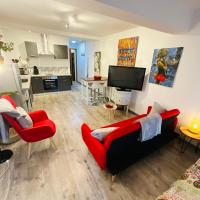 a living room with two red chairs and a flat screen tv at No 25 superbe apartment plein centre calme ,Netflix in Mirepoix