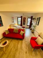 a living room with a red couch and a bed at No 25 superbe apartment plein centre calme ,Netflix in Mirepoix