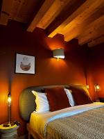a bedroom with a bed with orange walls and wooden ceilings at La Ferme du Bien-etre in Saint-Julien-Chapteuil