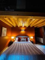 a bedroom with a large bed with a wooden ceiling at La Ferme du Bien-etre in Saint-Julien-Chapteuil