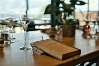 a book sitting on a table with wine glasses at La Ferme du Bien-etre in Saint-Julien-Chapteuil
