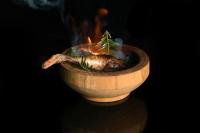a chicken in a wooden bowl with smoke at La Ferme du Bien-etre in Saint-Julien-Chapteuil