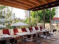 a patio with a couch and tables and chairs at Hotel Dama in Mexico City