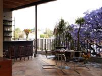 a patio with a table and chairs on a balcony at Hotel Dama in Mexico City