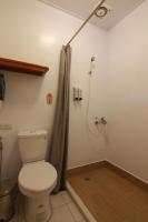 a bathroom with a toilet and a shower curtain at Tingtau Villa in Lugu Lake