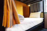 a bed in a room with an orange curtain at Angels Hostel Taipei Ximen in Taipei