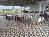 Un comedor con mesas y sillas sobre un suelo de baldosas. en LOSMEN 88, en Ratodena