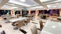 a dining room with tables and chairs and a tv at Delton Hotel in Kaohsiung
