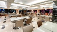 a restaurant with tables and chairs in a room at Delton Hotel in Kaohsiung