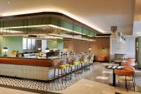 バンコクにあるトライブ リビング バンコク スクンビット 39の黄色いバースツール付きのバーがあるレストラン