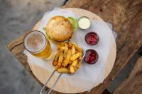 Victoria Falls Backpackers Zambia في ليفينغستون: طاولة مع ساندويتش وبطاطس مقلية ومشروبات