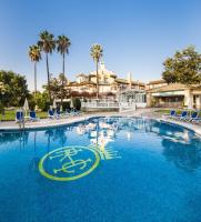 Una gran piscina con sillas azules y palmeras. en Globales Reina Cristina, en Algeciras