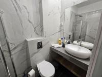 ein Badezimmer mit Waschbecken, Toilette und Spiegel in der Unterkunft Sun Sea Center in Eilat