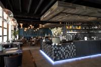 a restaurant with a bar with tables and chairs at Vakantiepark Eiland van Maurik in Maurik