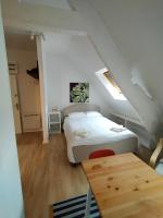 a small bedroom with a bed and a wooden table at Le 1 St Yves Studios in Tréguier