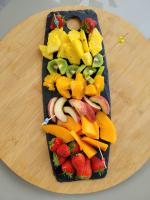 a tray of fruits and vegetables on a cutting board at La paillote idyllique in Faverolles-sur-Cher