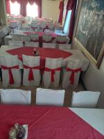 um quarto com uma mesa e cadeiras com arcos vermelhos em Juka em Međugorje