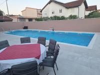 uma mesa e cadeiras em frente a uma piscina em Juka em Međugorje