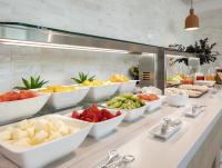 a buffet with many bowls of food on a counter at Hotel Málaga Alameda Centro Affiliated by Meliá in Málaga