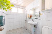 a white bathroom with a sink and a mirror at Yishin Garden B&amp;B in Pinghe