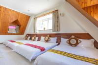 two twin beds in a room with a window at Yishin Garden B&amp;B in Pinghe