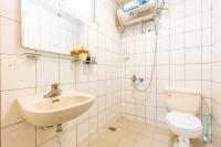 a white bathroom with a sink and a toilet at Yishin Garden B&amp;B in Pinghe