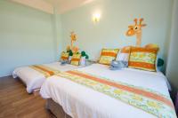 a bedroom with two beds with stuffed animals on them at Kenting Avignon in Hengchun South Gate