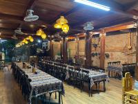 Un restaurante con mesas y sillas y una pared de ladrillos. en Pù Luông Sala Homestay, en Hương Bá Thước