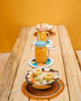 a table with a bowl of food and jars of juice at Banana Farm Eco Hostel in Arusha